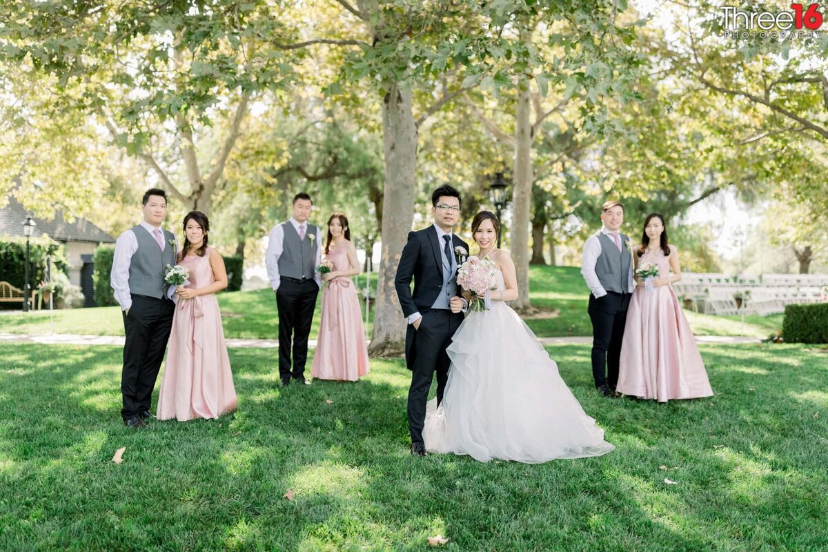 Bride and Groom pose together while Bridesmaids and Groomsmen pair off and pose together in couples