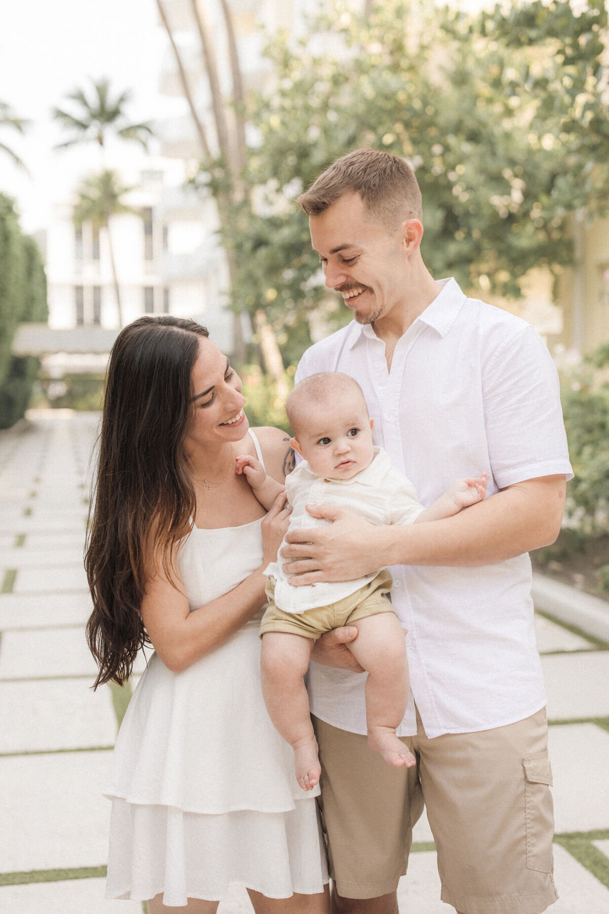 A family laughing while holding their 4 month old in West Palm Beach, FL