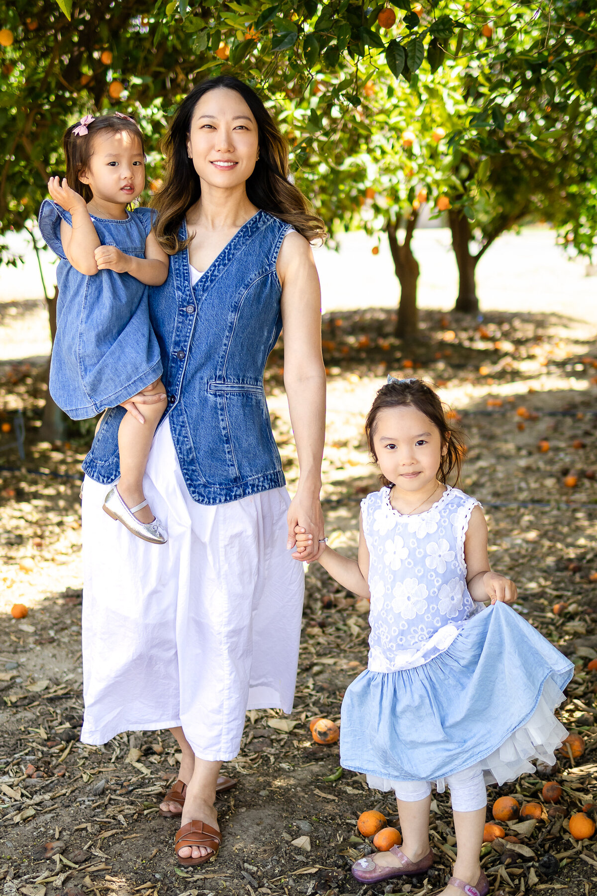 Mom sharing a warm hug with her two daughters children during a playful outdoor session – lifestyle family photography by Ellobelle Photography, San Francisco Peninsula