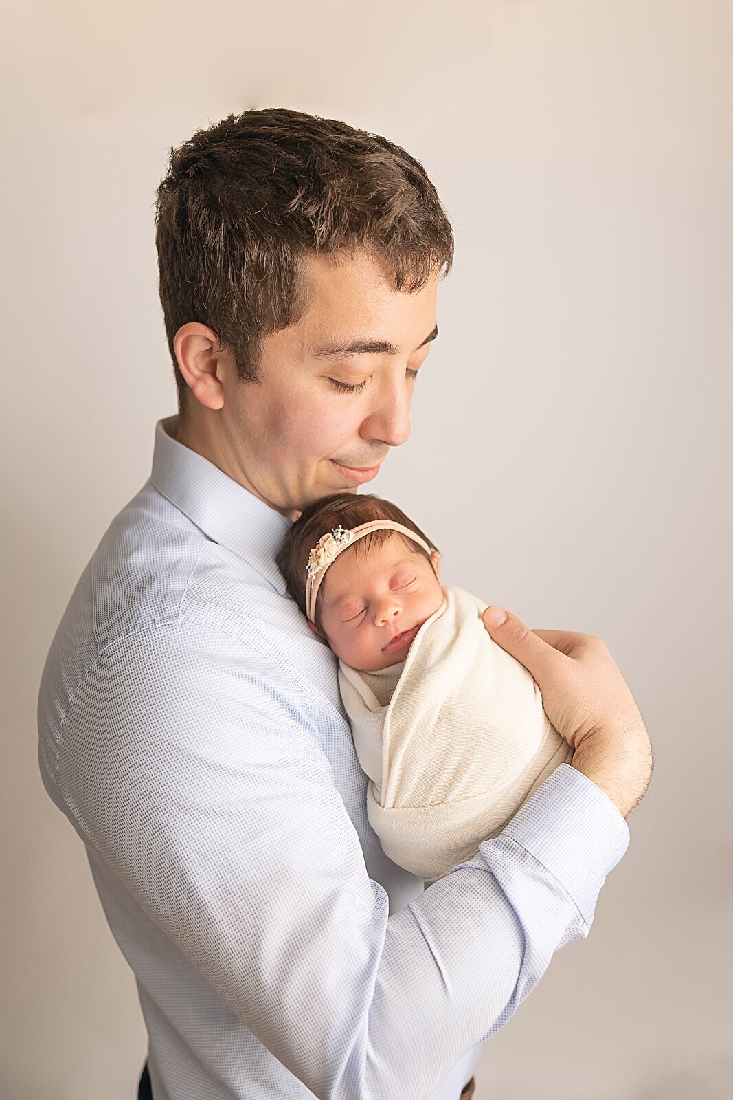 dad holding newborn baby girl for photo session