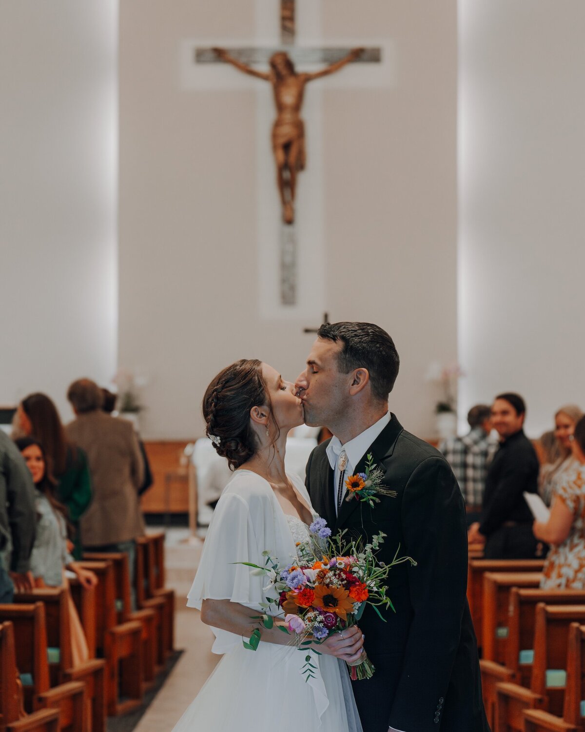 bride and groom kissing in a church