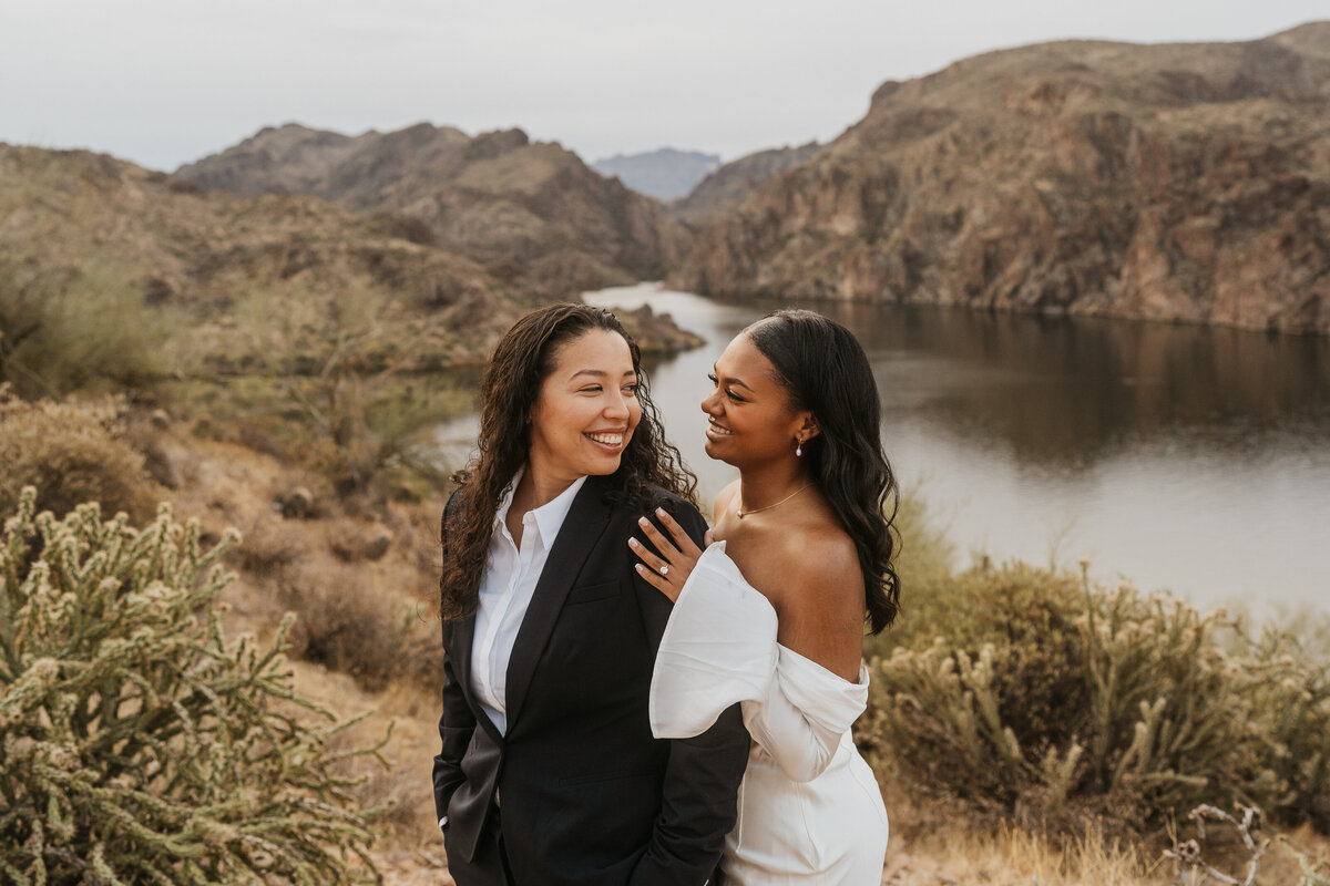 A person standing behind their partner as they look back and smile at each other 