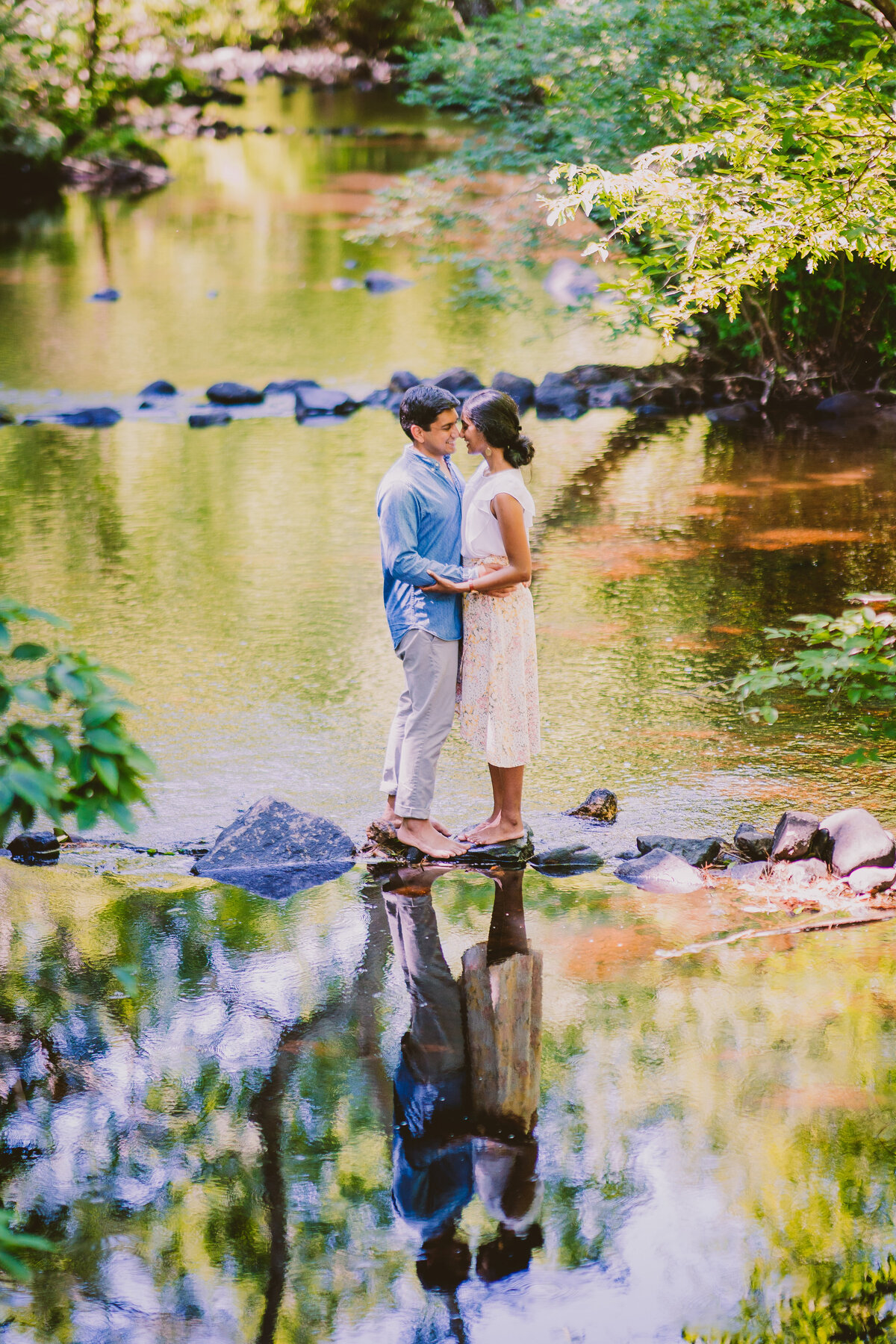 A couple sharing a moment in the middle of a stream at the devil's hopyard state park in connecticut during their engagement session