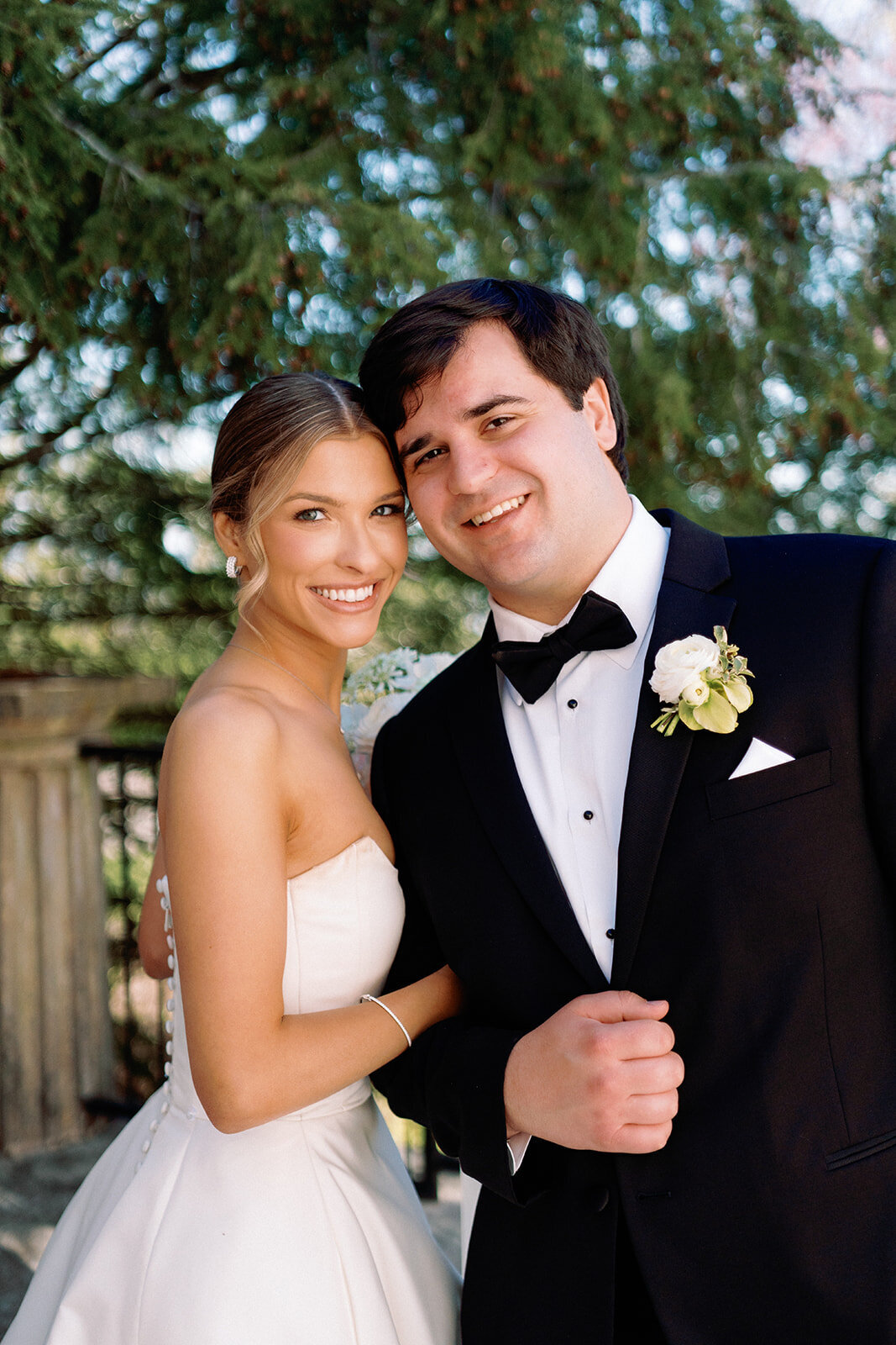 Bride and groom smiling closely together in a romantic portrait on the terrace at Burritt on the Mountain in Huntsville, Alabama, photographed by Perry Hancock.