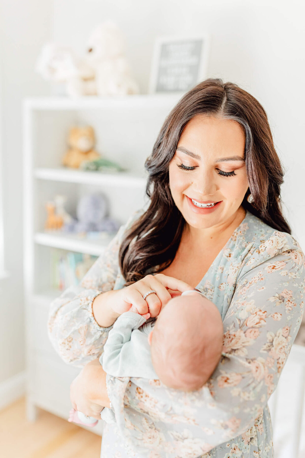 A mother smiles at her baby in his animal-themed nursery