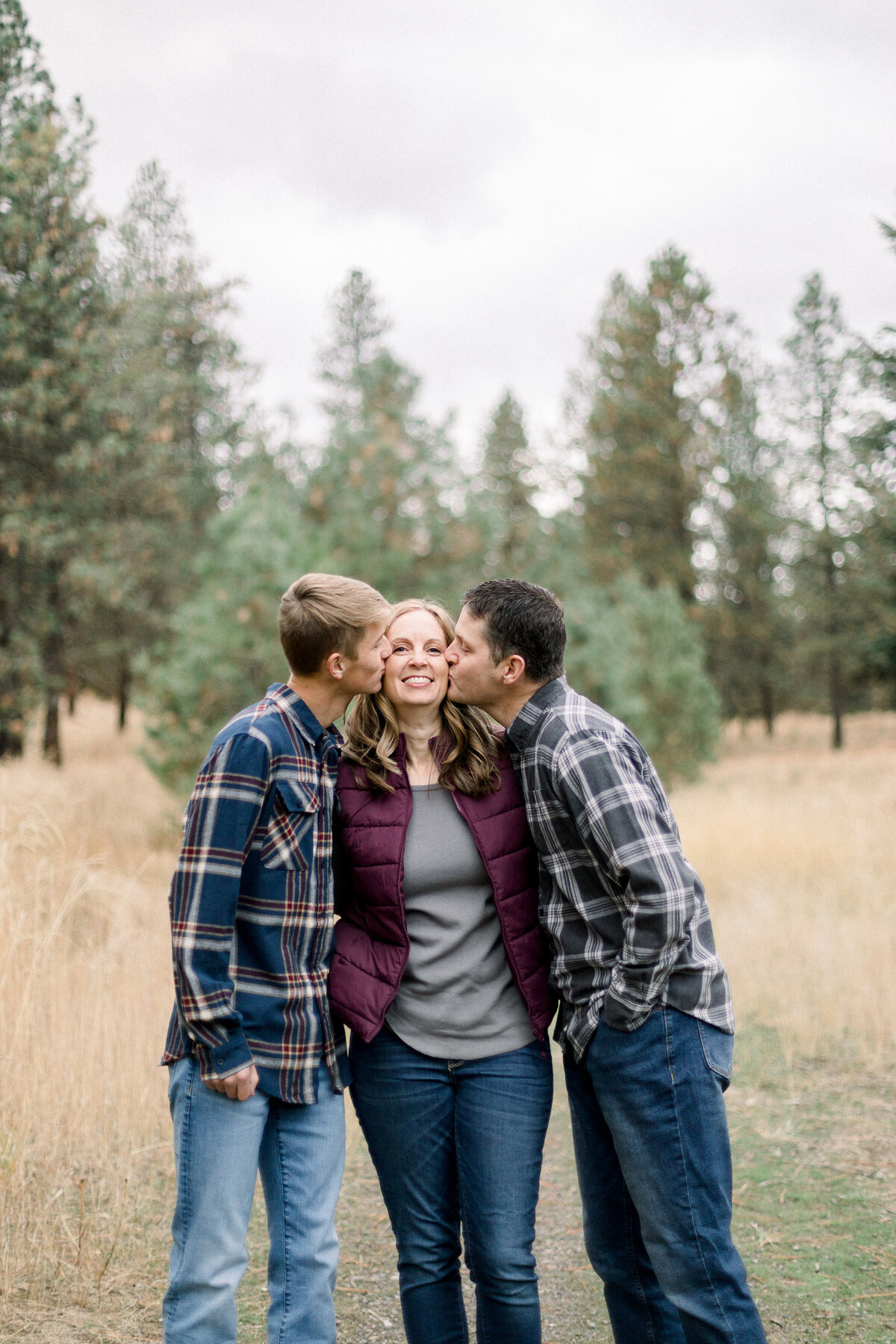 Son and dad kissing mom on cheek-taken by Family photographer in Spokane WA