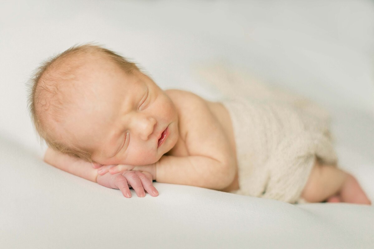 baby posed on a light and airy backdrop in their Cincinnati studio newborn session