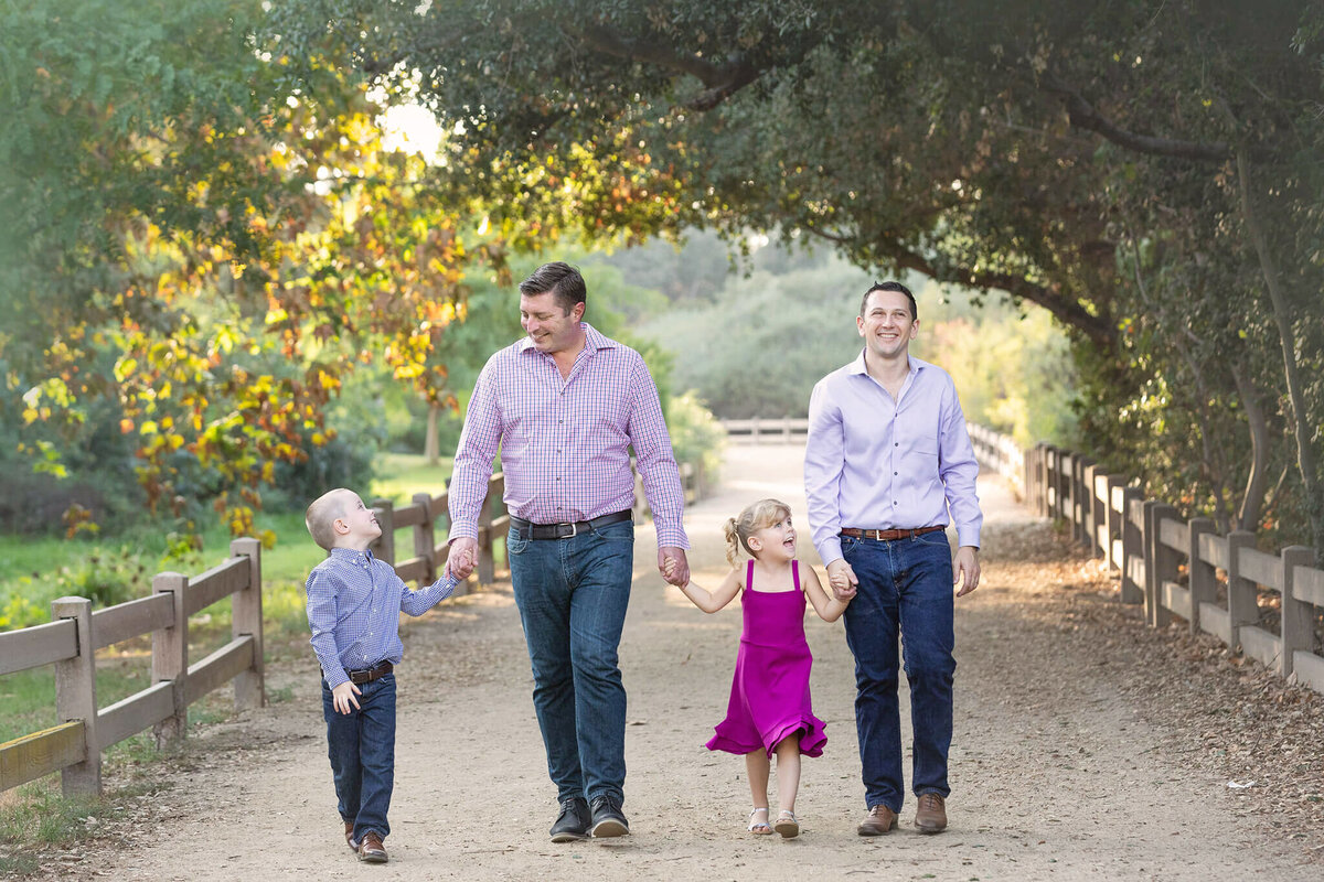 Two dads with their twins wealking through Griffith Park photographed by Los Angeles photographer
