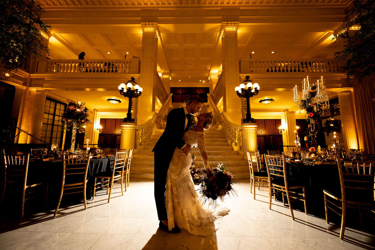 A bride and groom are kissing in a large room