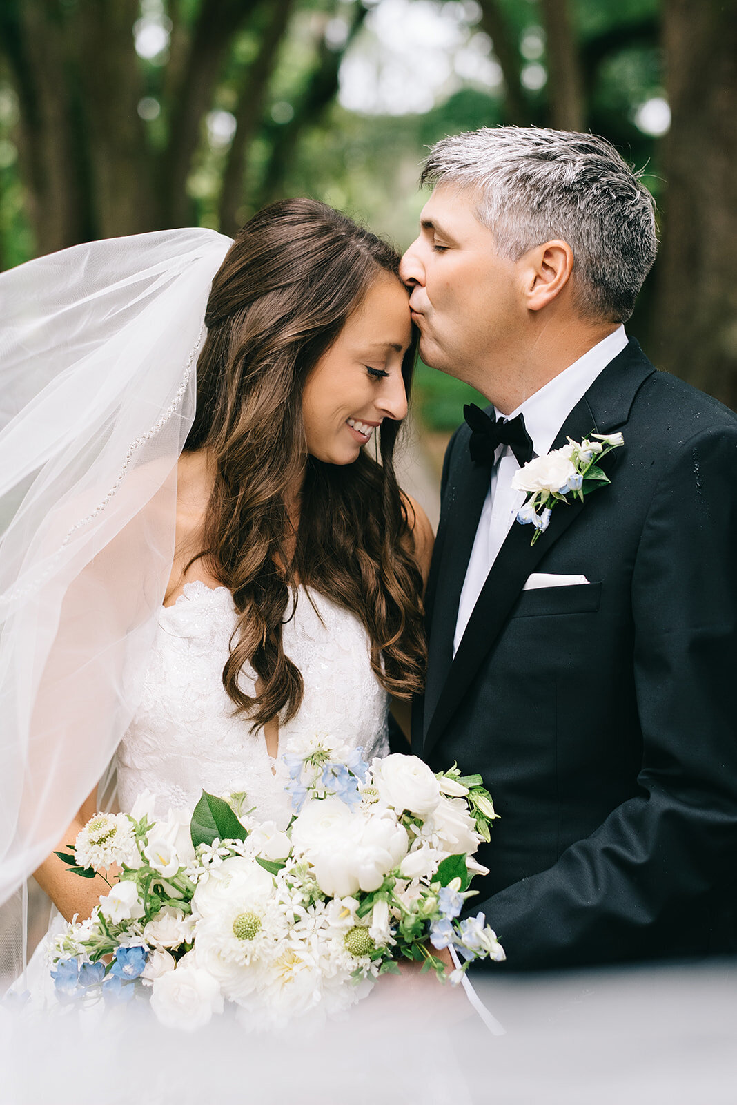 Bride and groom with white and blue bouquet designed by Abby Grace Florals at Greenville SC wedding