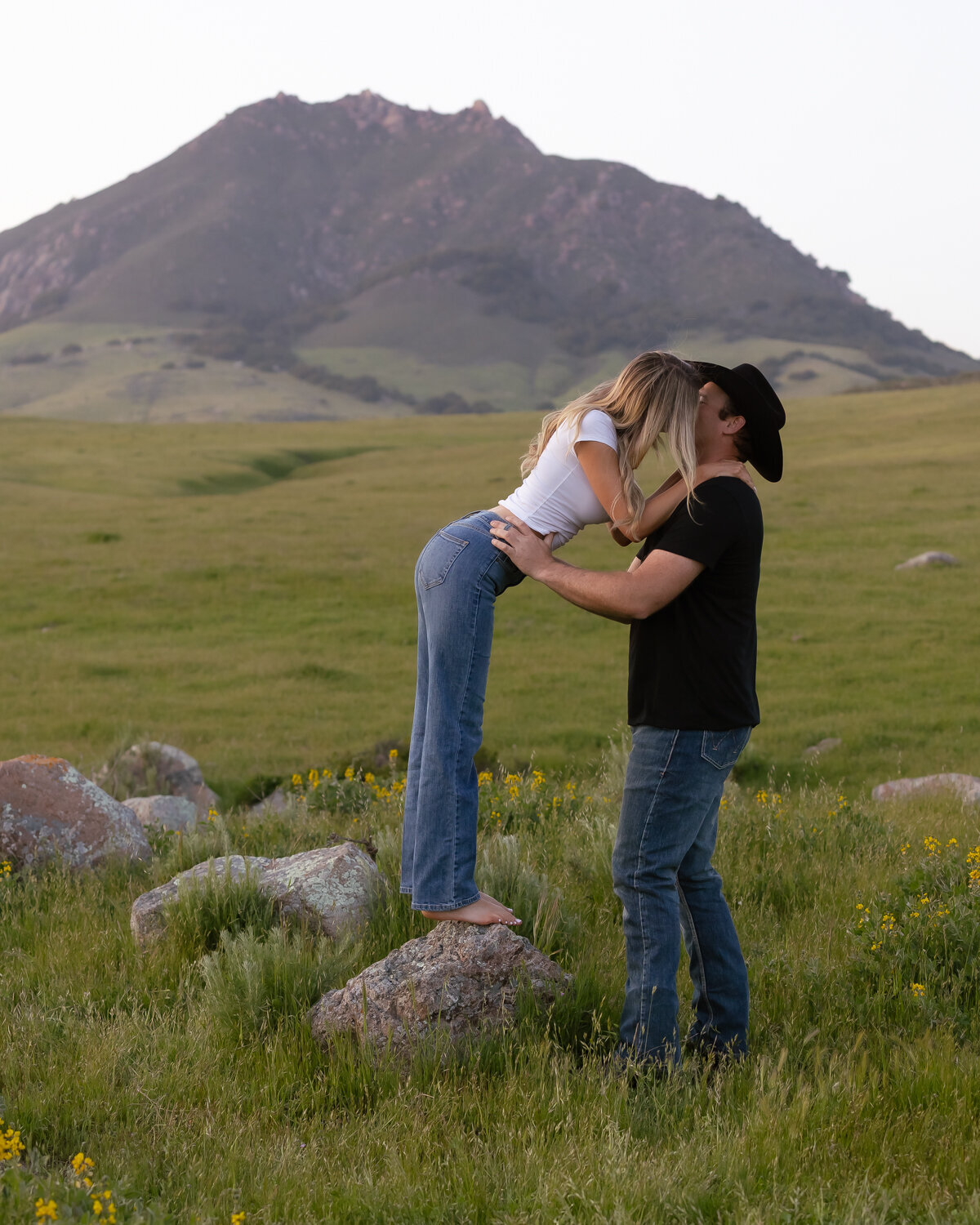 Candid couple during engagement photos in field with hills in San Luis Obispo 