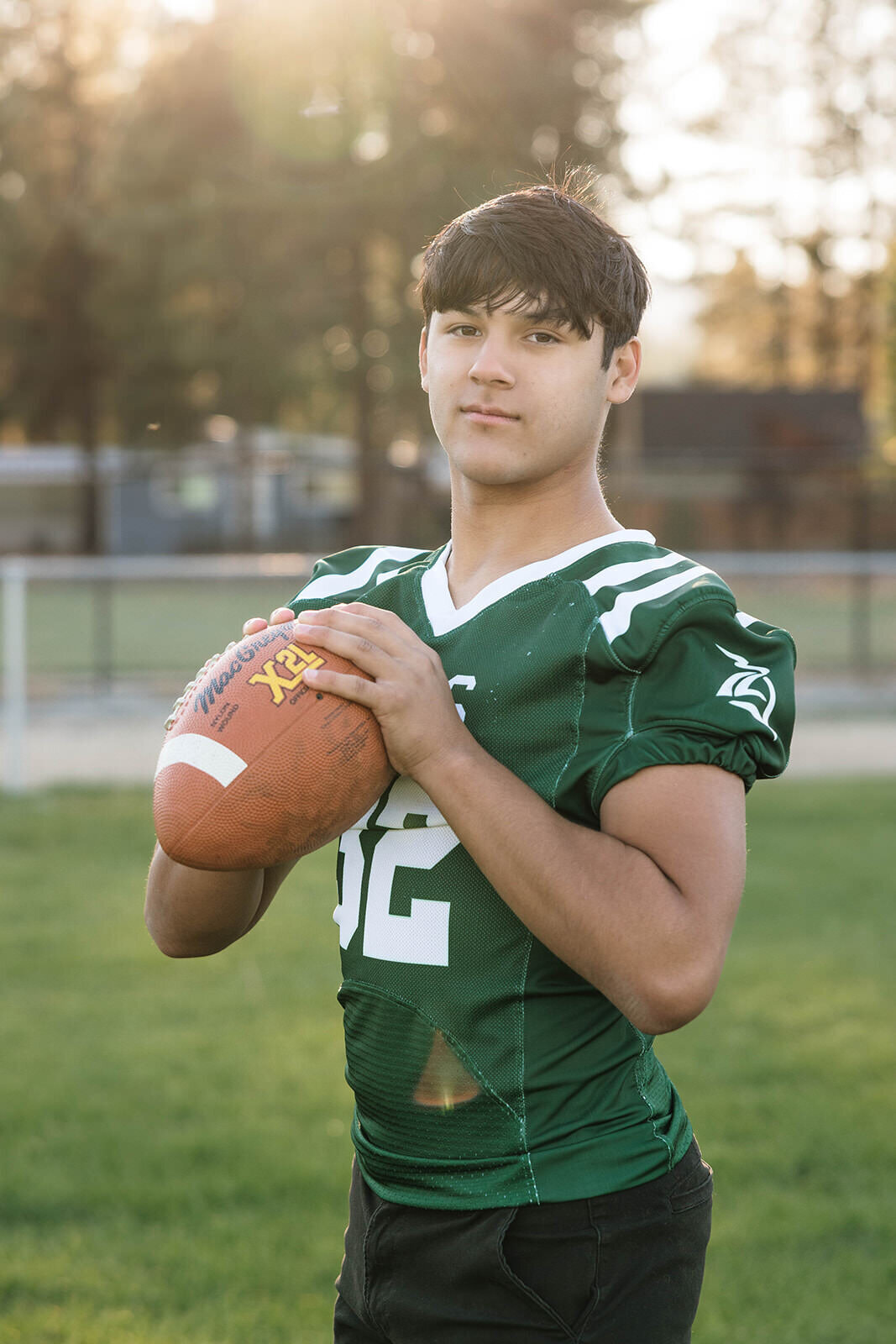 Senior football player throwing a football on the field