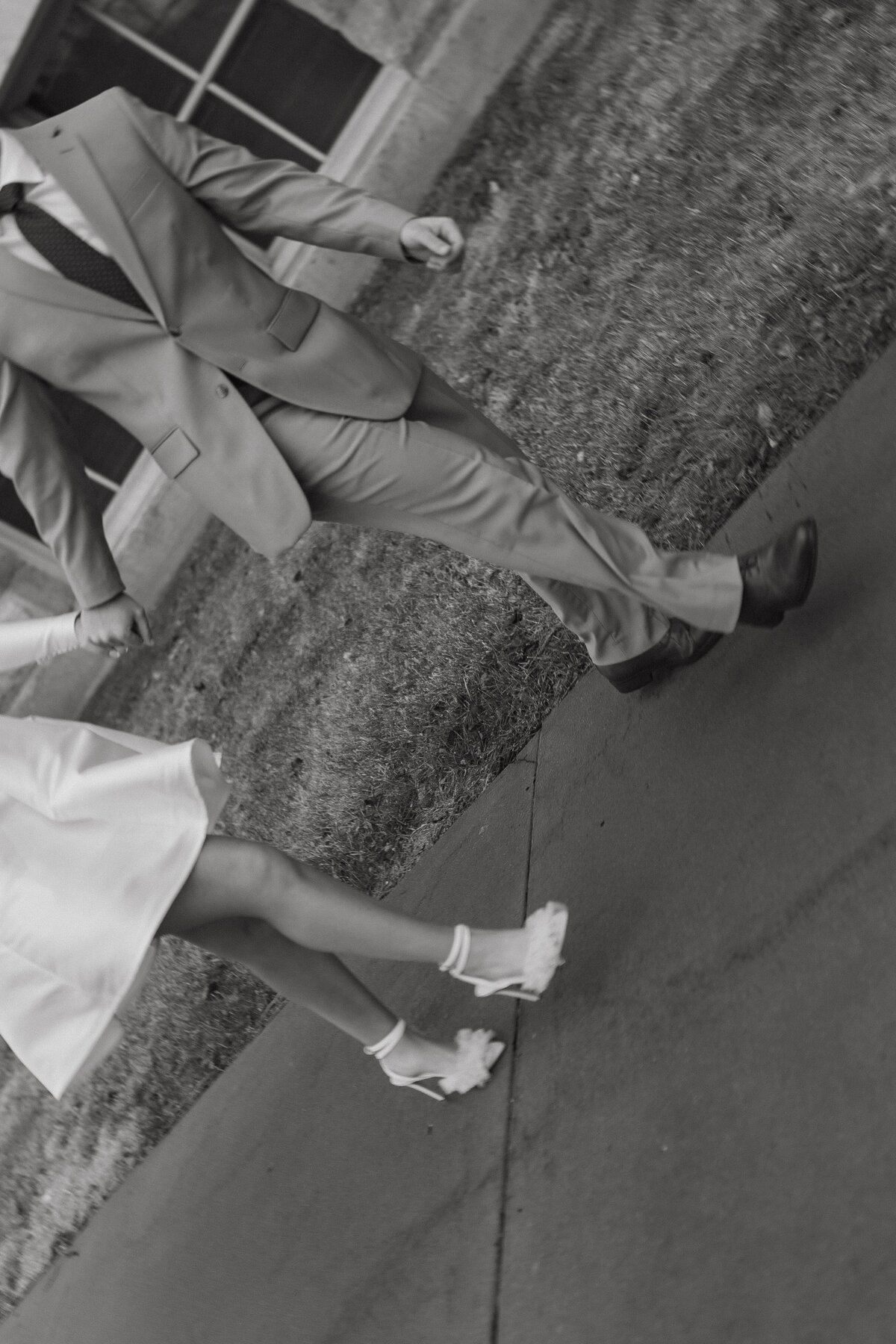 bride and groom walking on sidewalk hand in hand