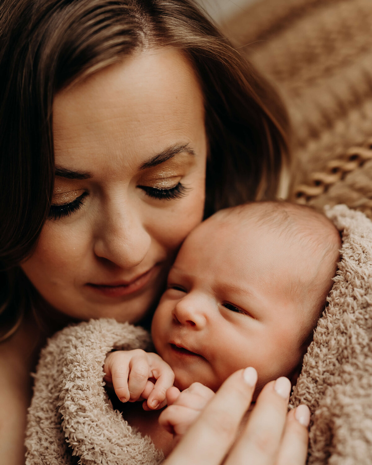 close up of mother with her face next to her newborn son