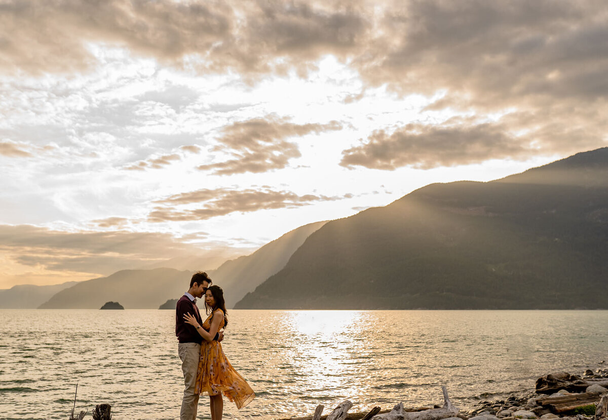 couple standing in front of a beautiful sunset during their engagement shoot