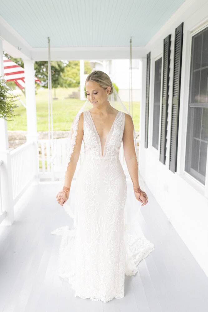 bride posing outside on porch - gold shoes and wedding details - branford house wedding