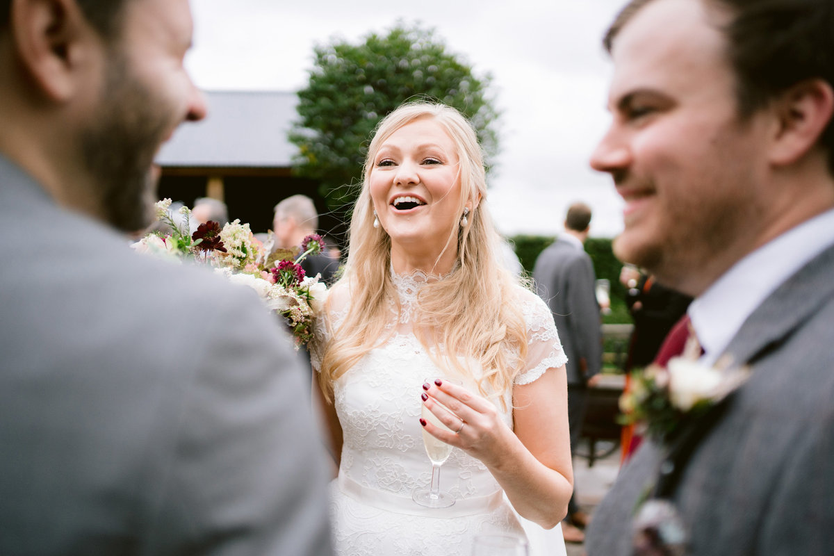 reportage wedding photo if bride laughing with guests