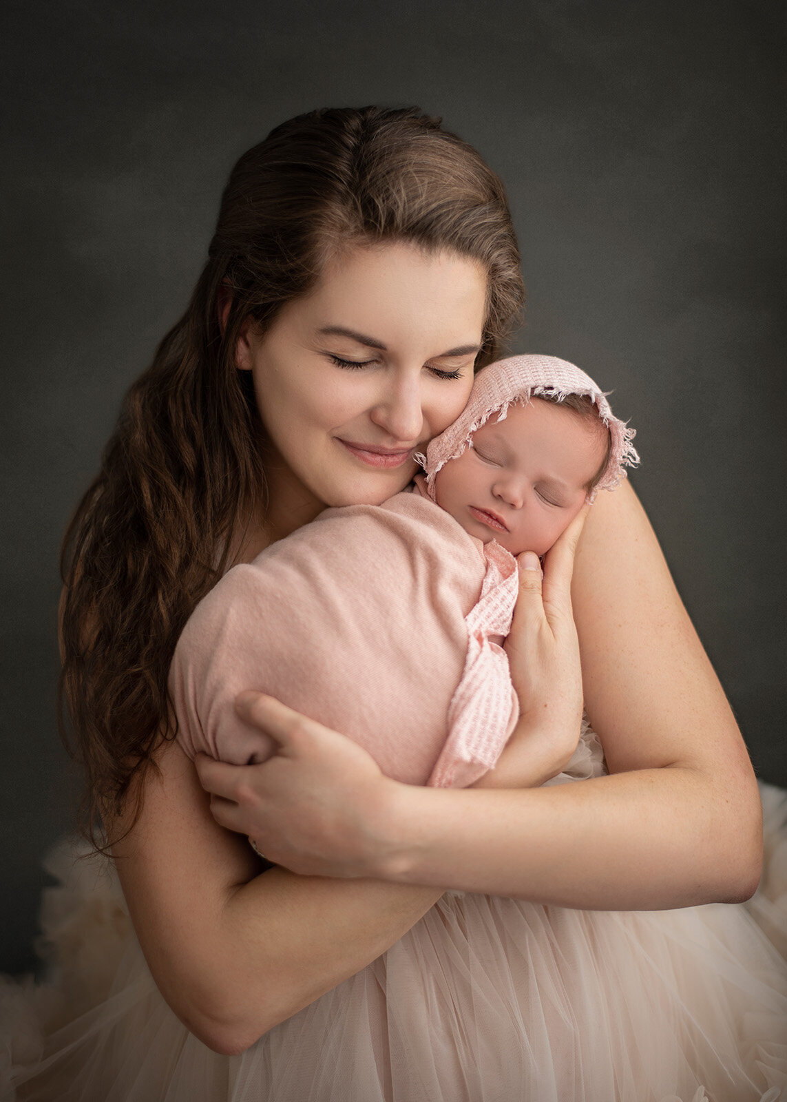 mom snuggling newborn at their newborn photo session