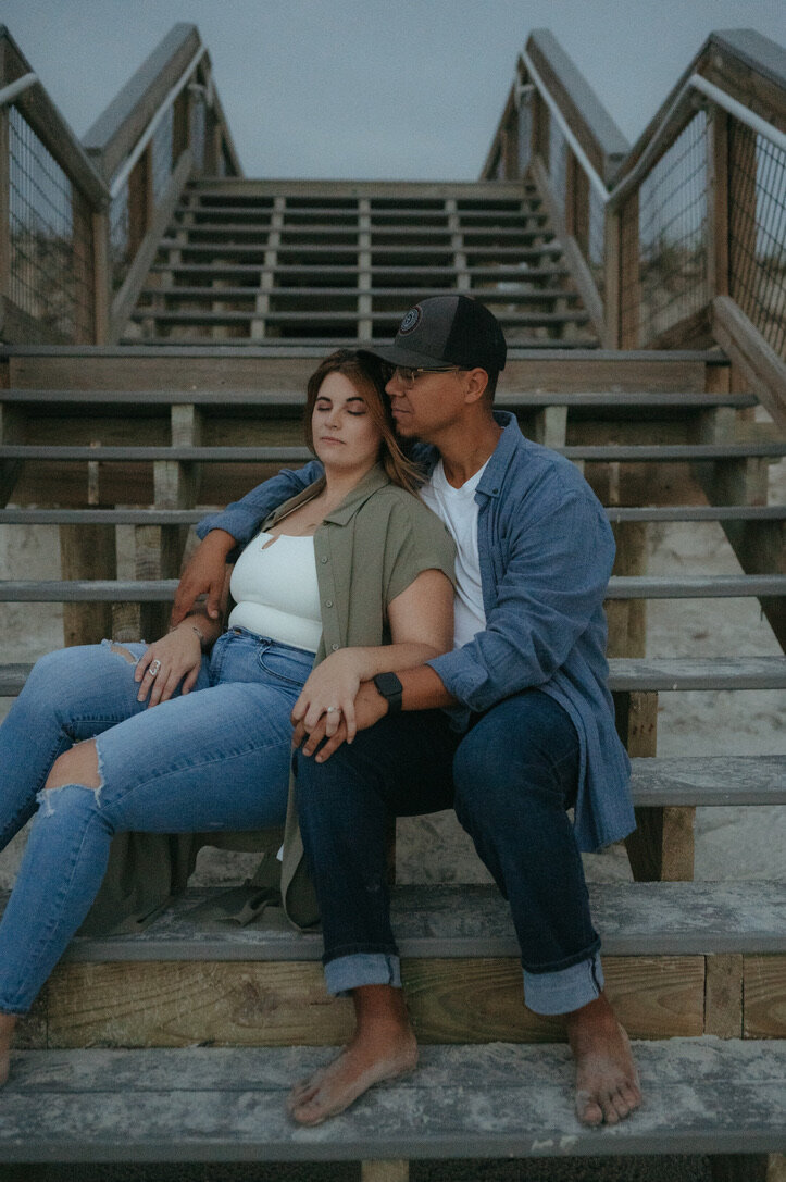 couple sitting on stairs during engagement photos