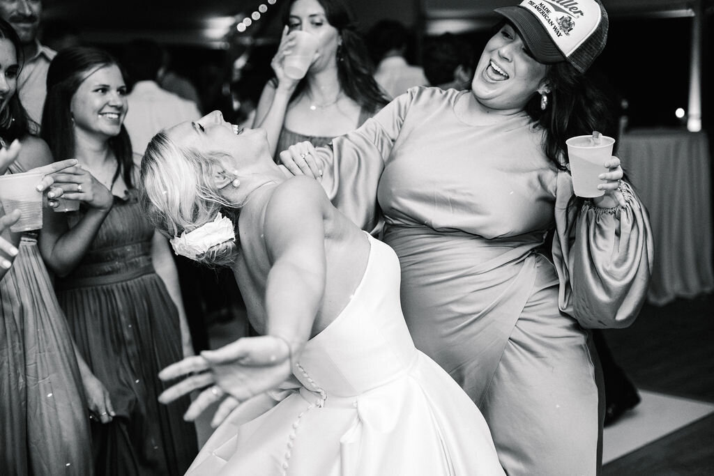 Bride and bridesmaid shimmying in black and white