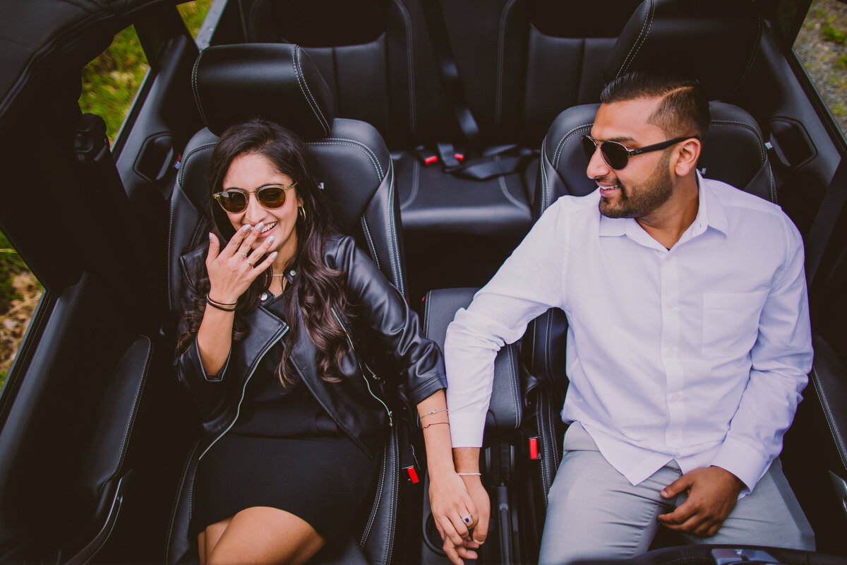 A couple laughing in their jeep wrangler during their roadtrip engagement session