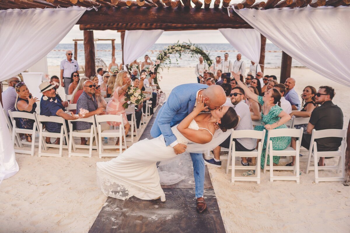 Groom dips bride after wedding ceremony at wedding in Riviera Maya