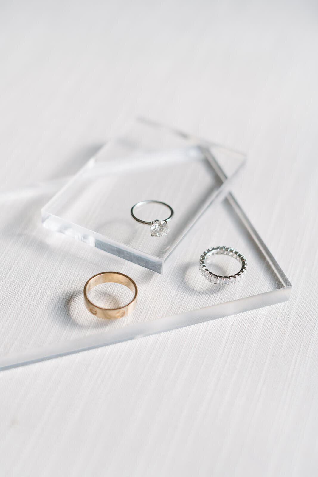 Wedding rings displayed on a reflective surface at St. Regis Aspen, surrounded by elegant details and soft, romantic lighting.