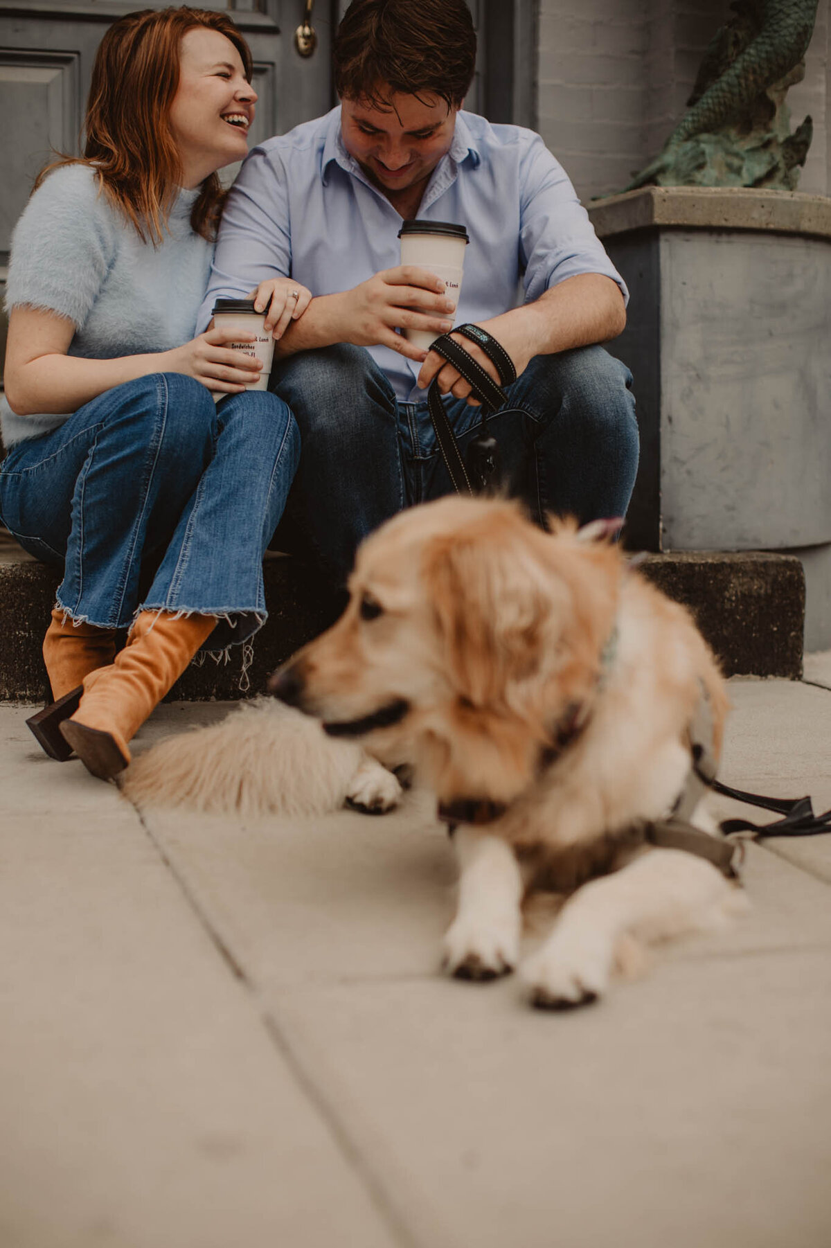 A dog laying on the ground in front of two people 