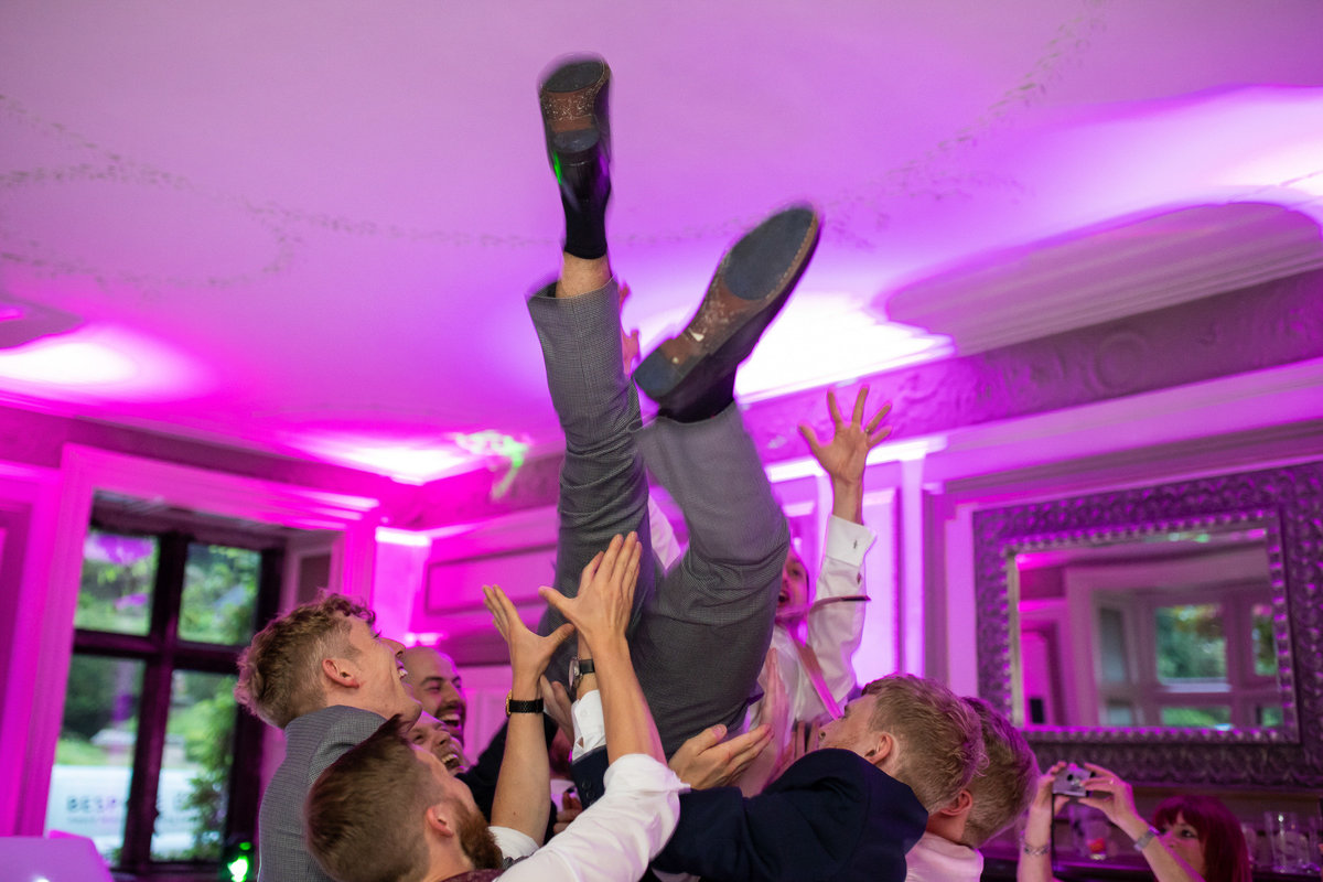 Groom being lifted above dance floor at Langdon Court Wedding Plymouth
