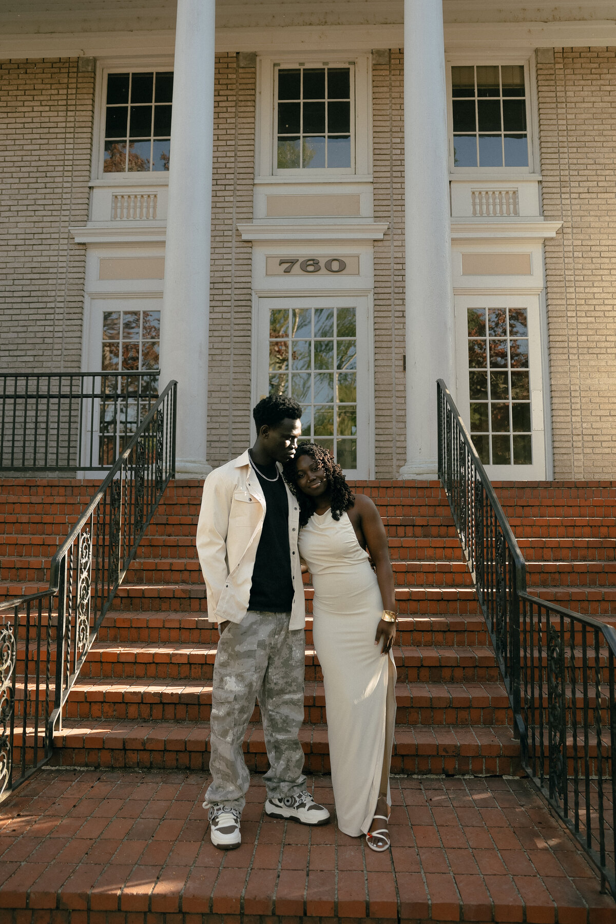 Modern City Engagement Photo with Couple Standing on Brick Steps at Sunset