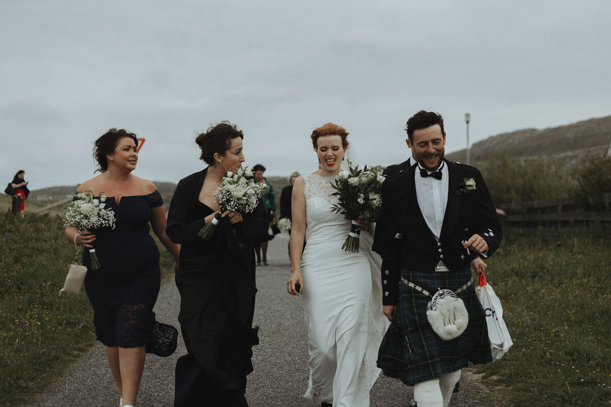 bride and groom with guests walking  together