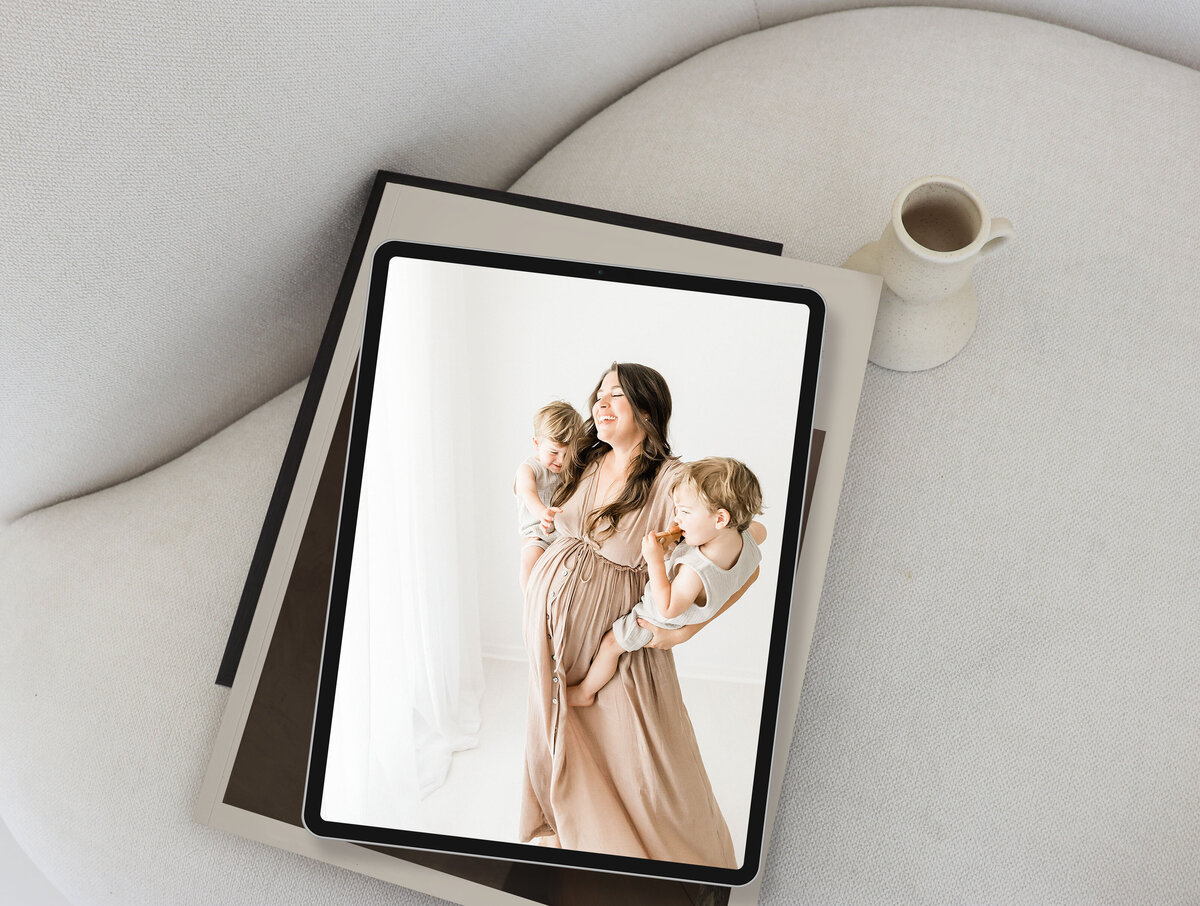 an iPad with a digital image of a pregnant woman  and her twin boys dancing in front of a big window