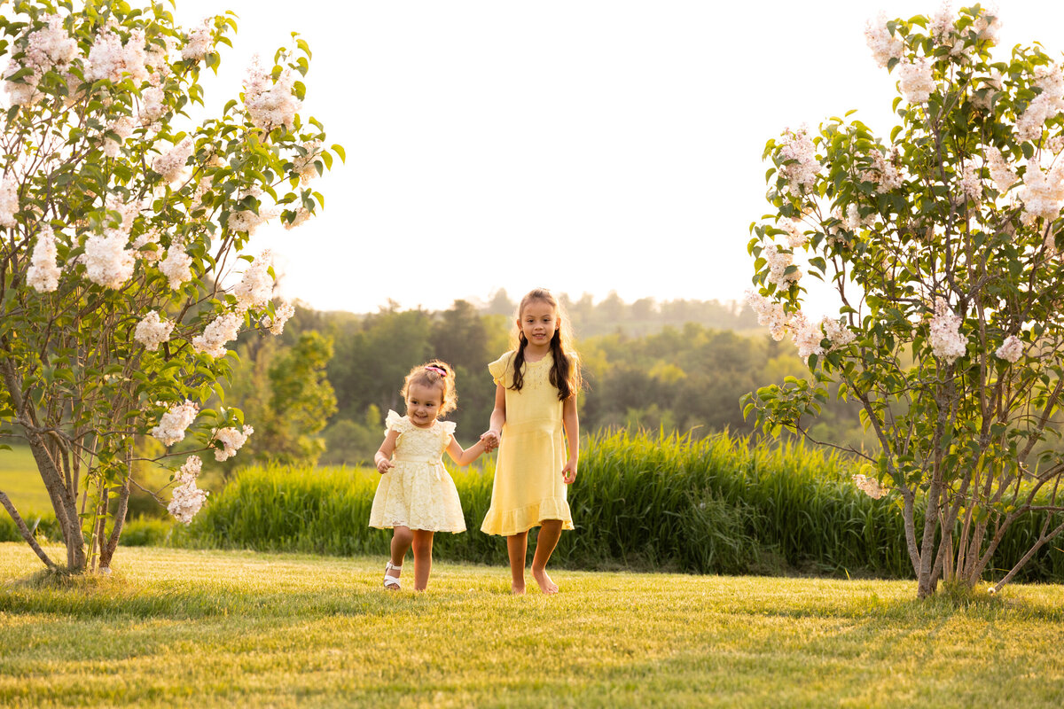 Two little girls walk holding hands on a beautiful Vermont evening.