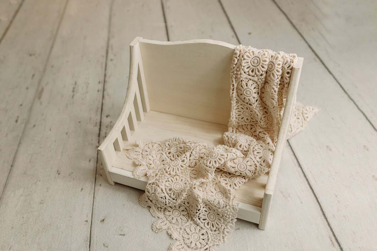 White ornate daybed prop used for newborn photography  sessions.