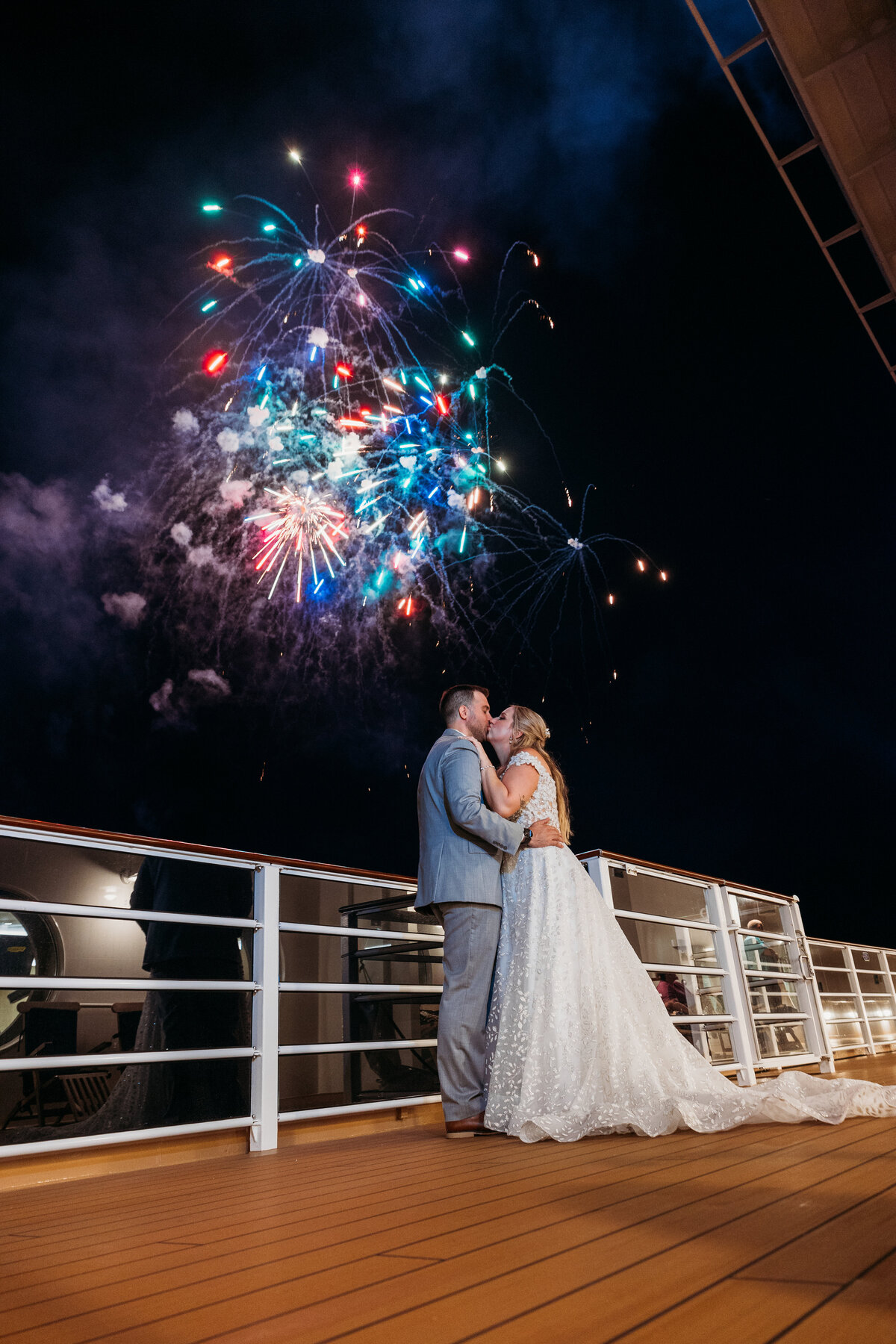 A colorful explosion of fireworks lights up the sky as the newlyweds embrace on the Disney Wish deck during their wedding night.