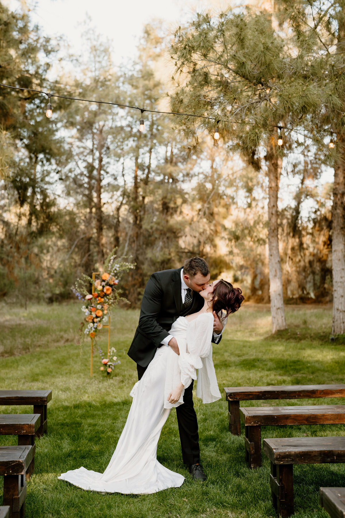 Bride and groom kissing at end of the aisle