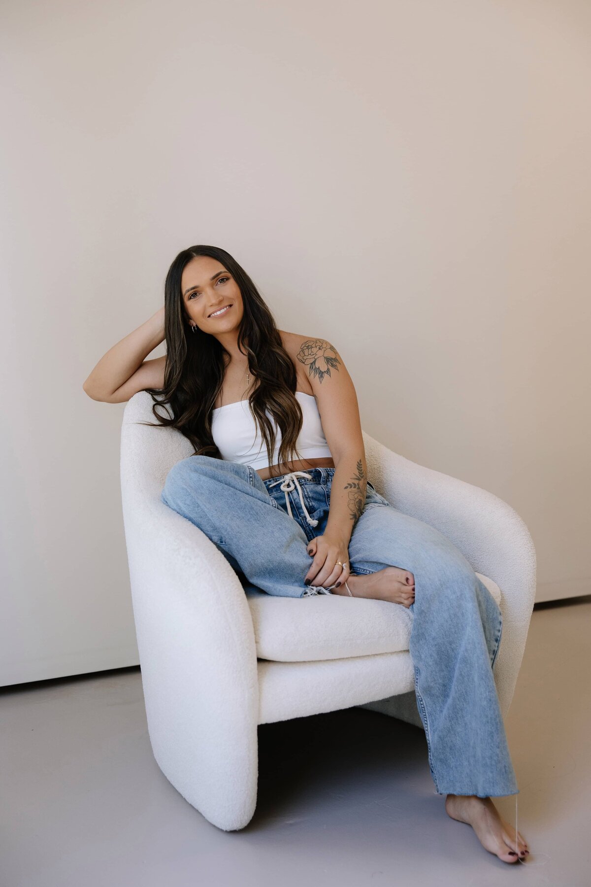 A woman sits on a chair and poses for a photo during her branding session in Northern Colorado.