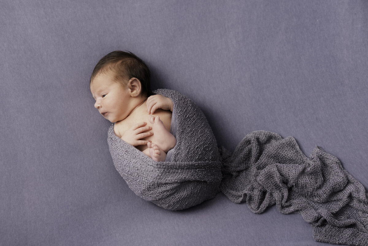 Bébé nouveau-né sur fond gris