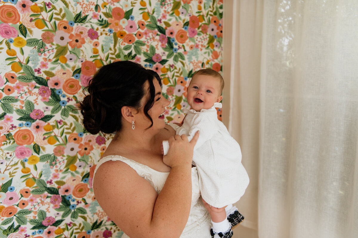 Bride holding baby during wedding day South Bend