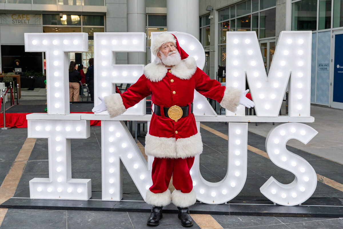 Santa Claus standing in front of the Teminus busiling sign in Atlanta during the holiday event by Laure Photography