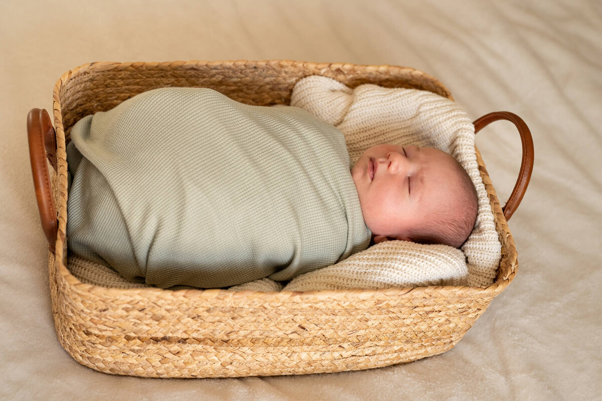 newborn sleeping in a basket