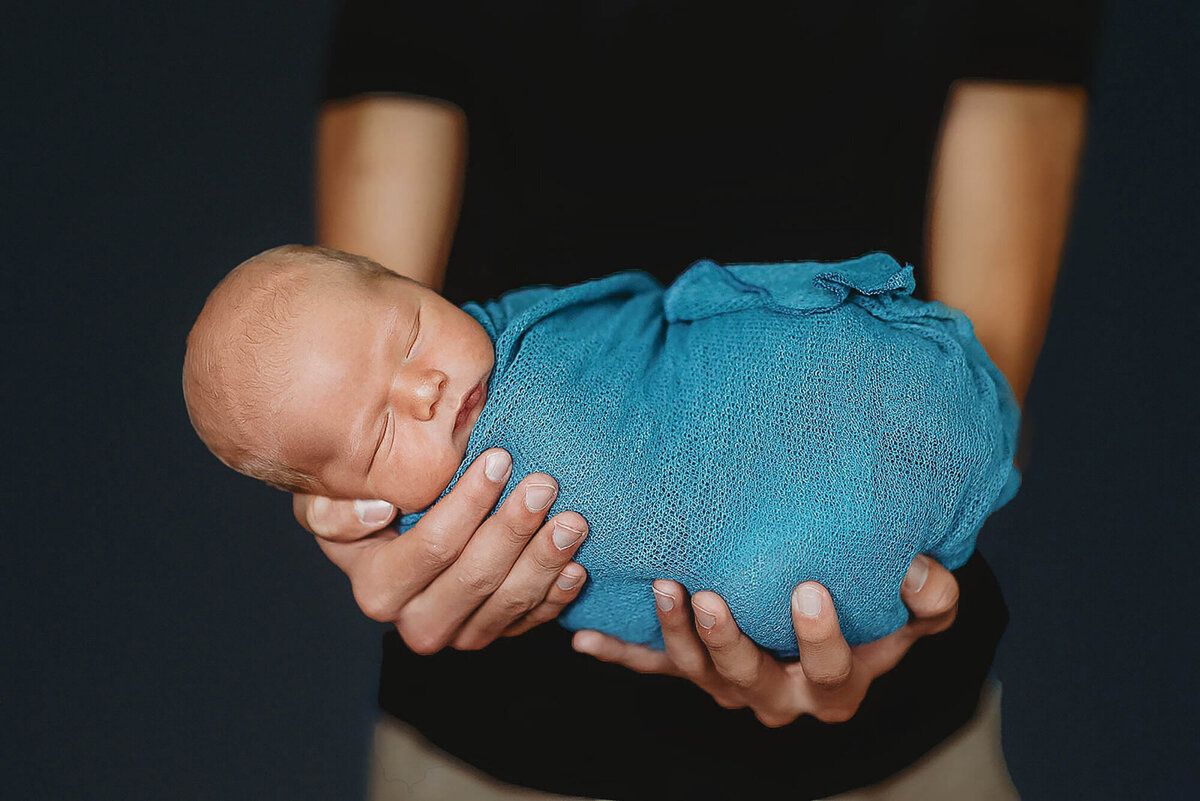 Father holds his infant for Newborn posed for Baby Photos in Charleston, SC.