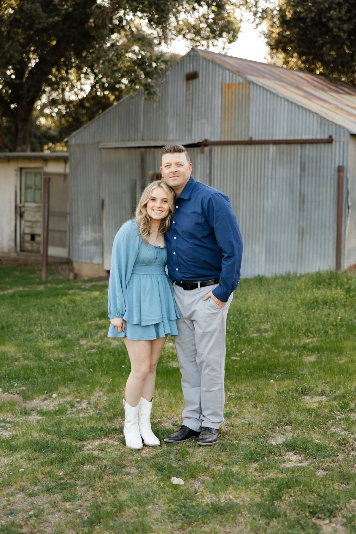 Father standing closely with young daughter near rustic barn backdrop. Photographed by Yucaipa family photographer Kaitlyn Dawn Photography.
