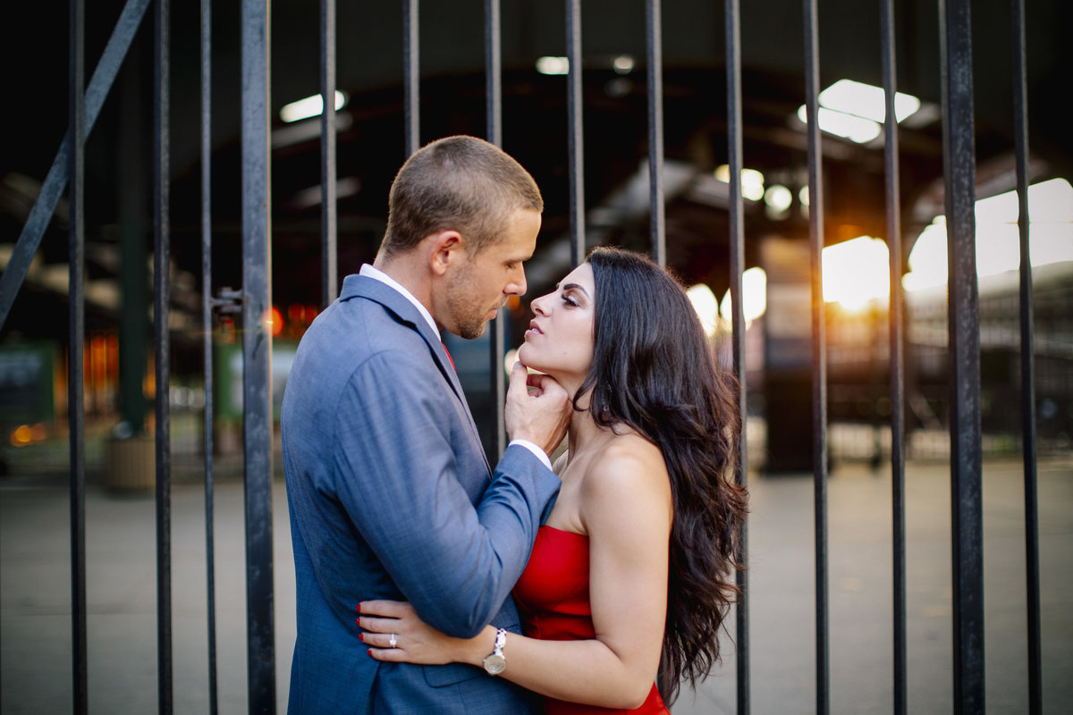 engaged couple kissing by old train station at  liberty state park