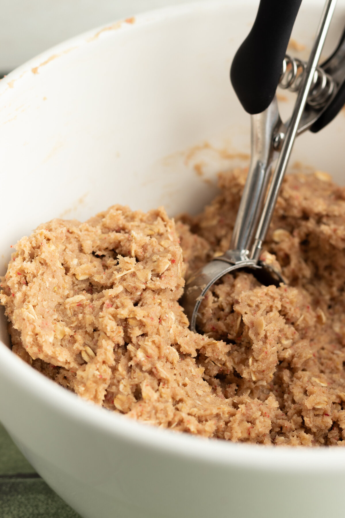 cookie dough being portioned with a cookie scoop