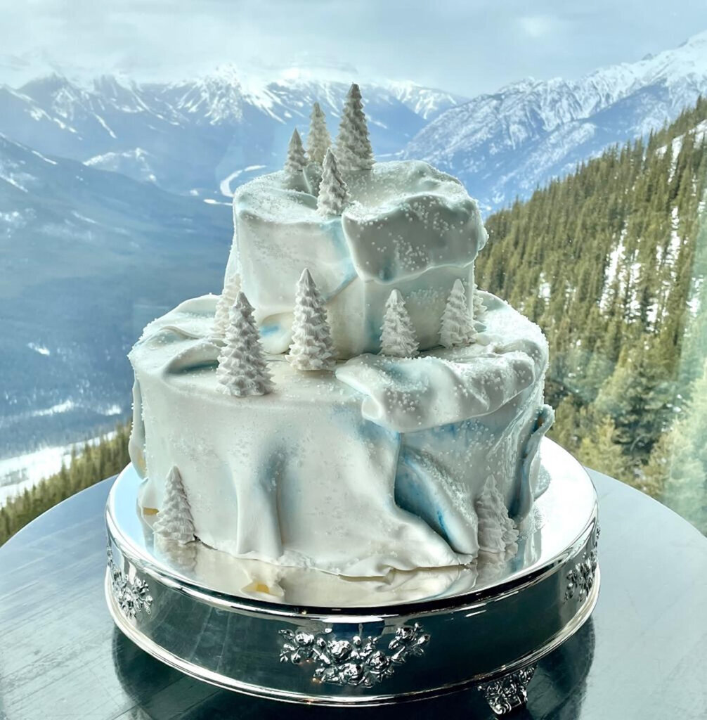 Unique textured two-tiered textured wedding cake, with white and blue snow covered evergreen trees, created by Chartier YYC, elegant cakes & desserts in Calgary, AB, featured on the Brontë Bride Vendor Guide.