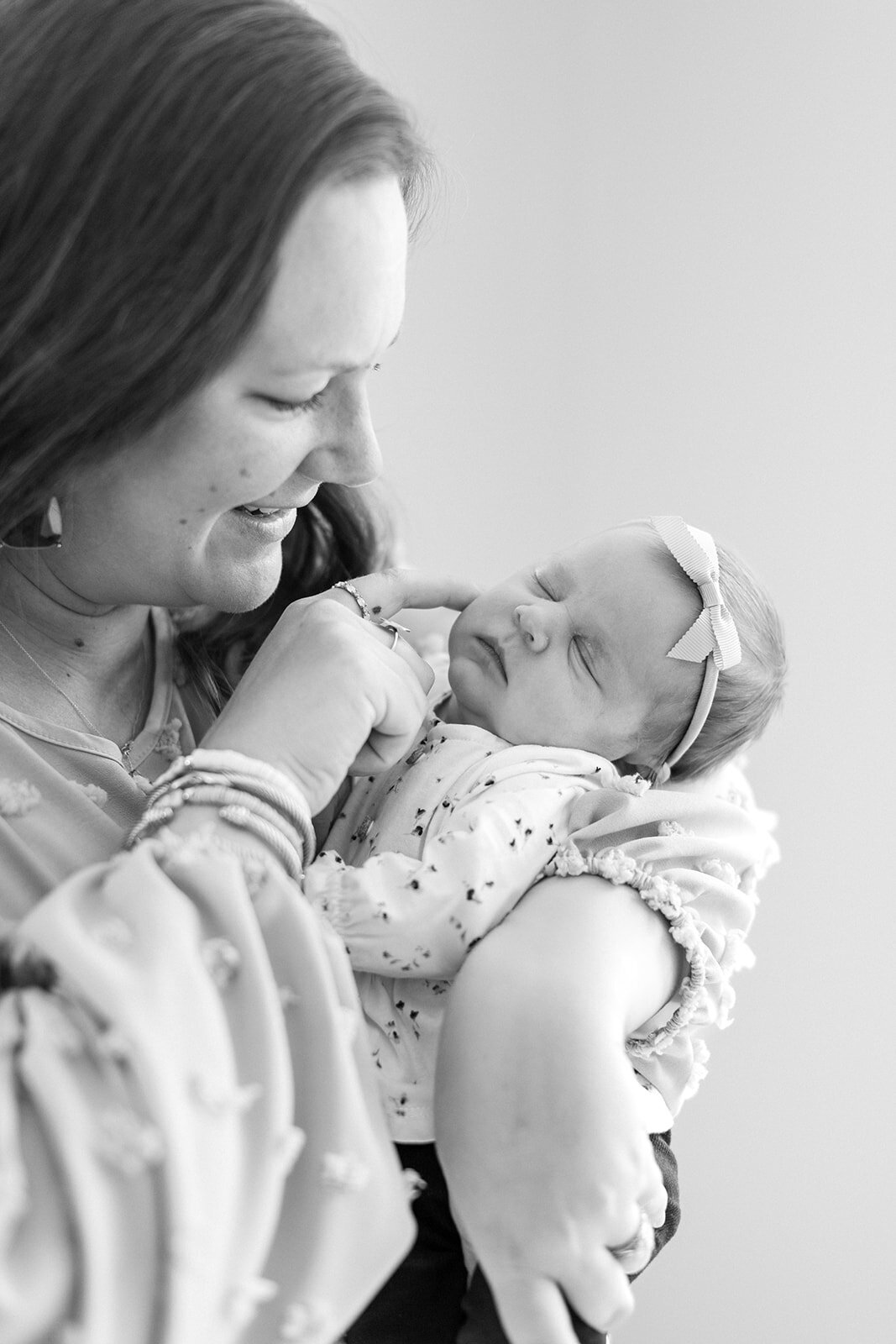 Mom holding newborn baby girl during in-home session