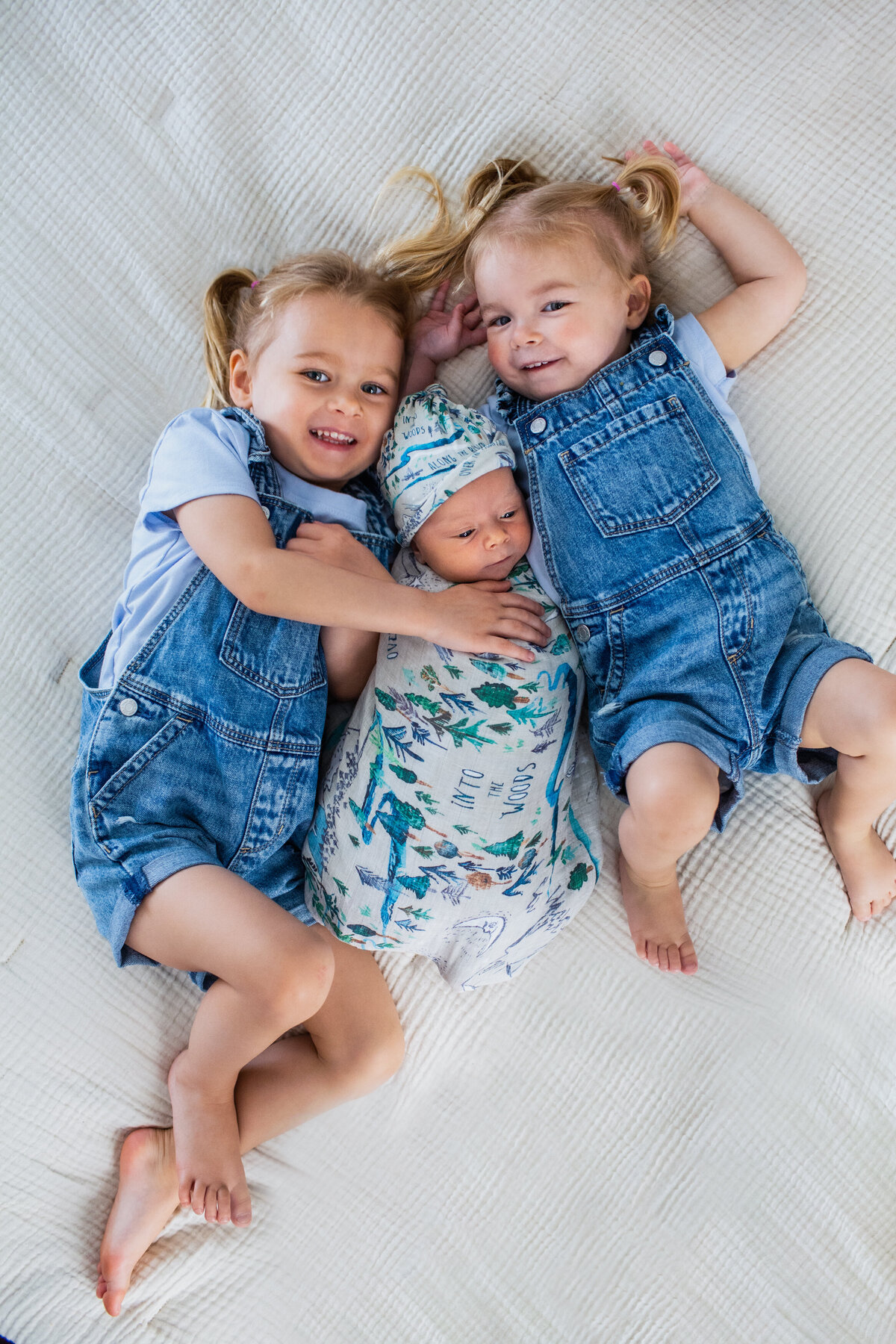 Sibling snuggles on mom and dad's bed.