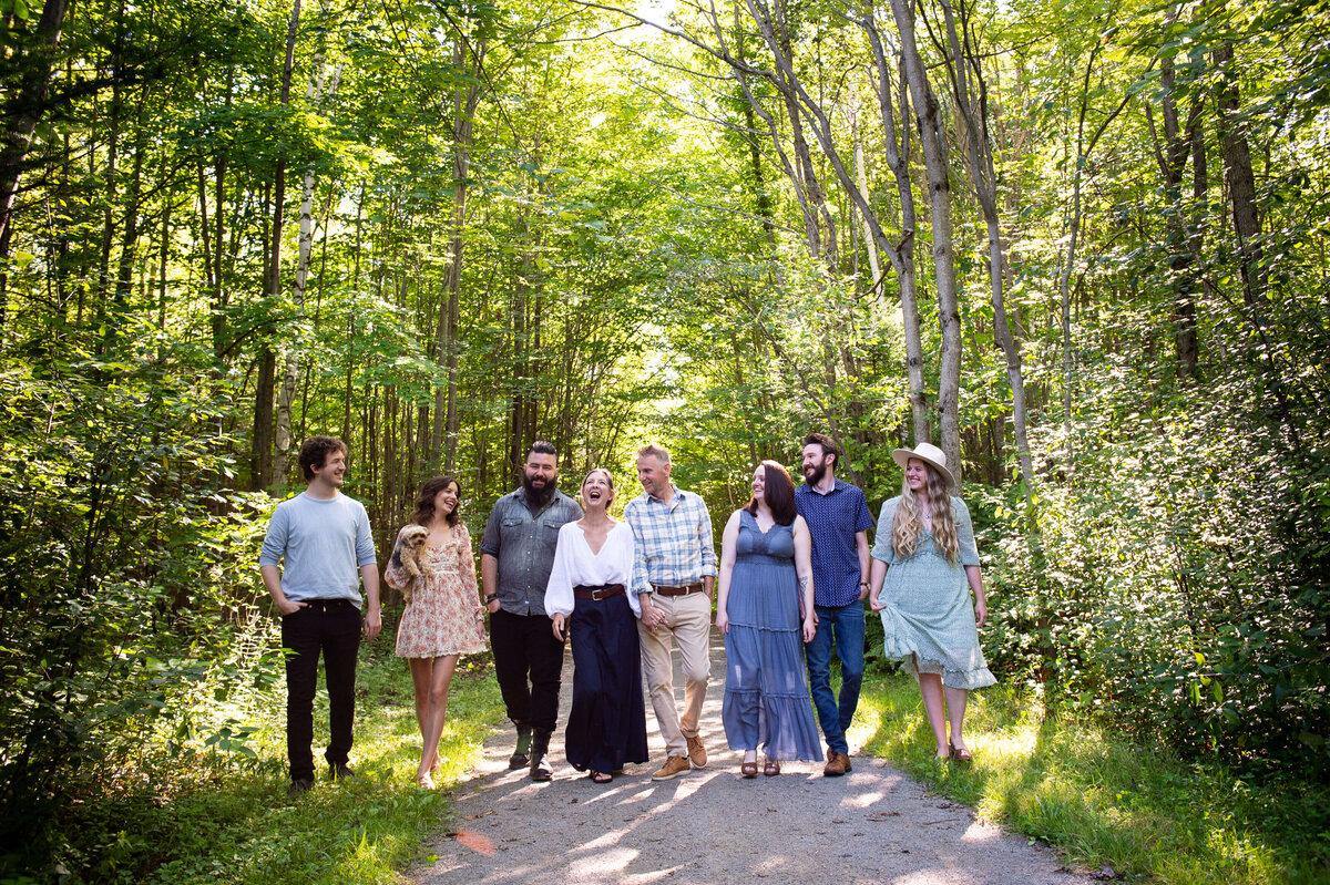 mom and dad with their adult children walking in the woods captured by Ottawa family photographer JEMMAN Photography
