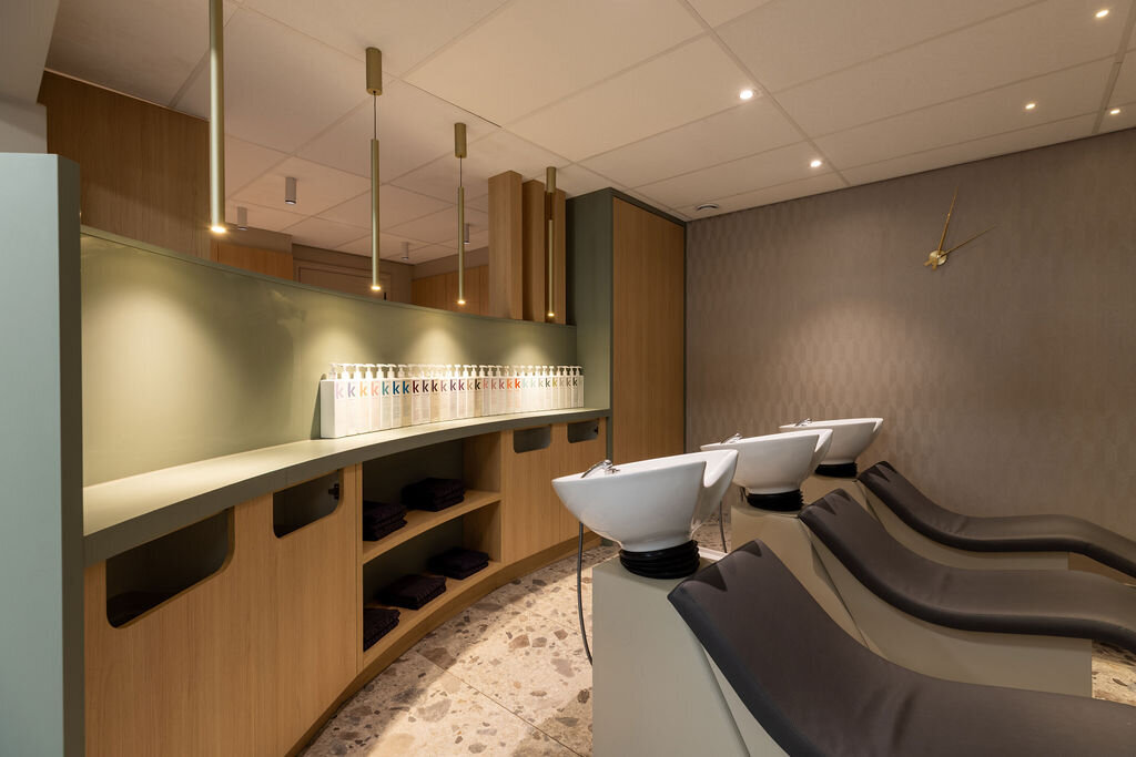 Een stijlvolle en functionele wasruimte op maat, ontworpen voor optimale beleving en werkcomfort binnen een kapsalonomgeving.
